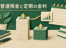 高さの違う硬貨の山と貯金箱、背景にカレンダーがあるイメージ