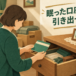 実家の引き出しから見つかった古い通帳を手に取る人のイメージ